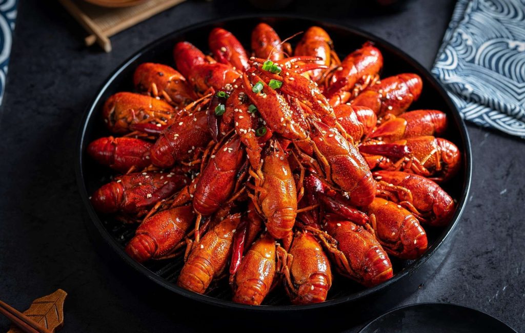 Piring besar berisi Udang Selingkuh dengan siraman saus Padang kental dan irisan jagung manis